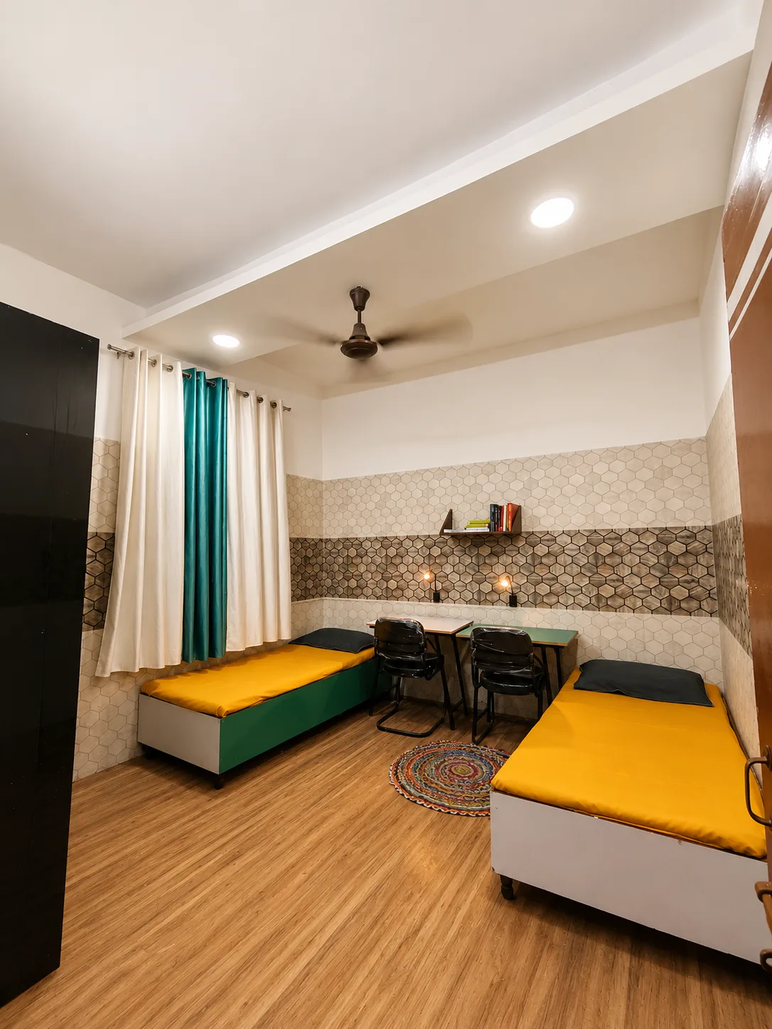Double sharing room at Duhomes boys PG Kamla Nagar, teal curtains and two beds